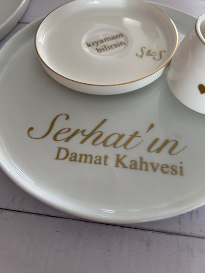 White ceramic plate with gold text on a light gray surface