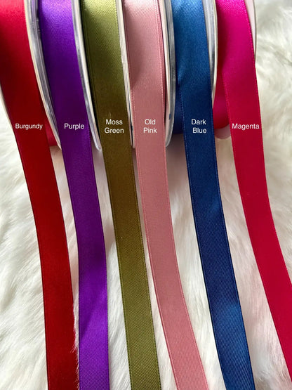 Collection of colorful ribbons with labeled colors on a textured surface