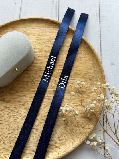 donkerblauw verlovingslint met witte tekst en gepersonaliseerde namen